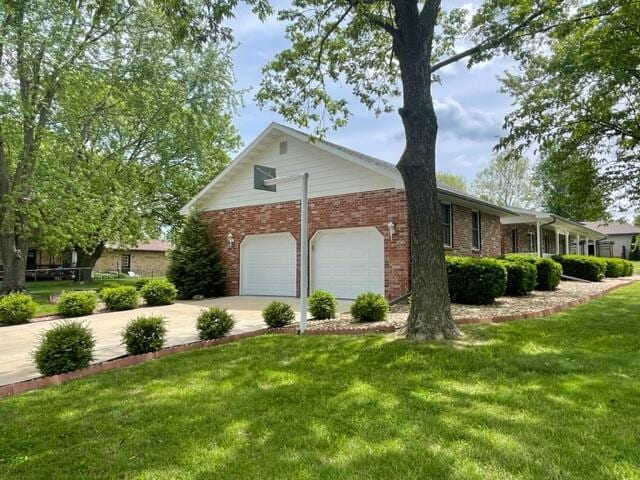 view of property exterior with a yard, brick siding, driveway, and an attached garage
