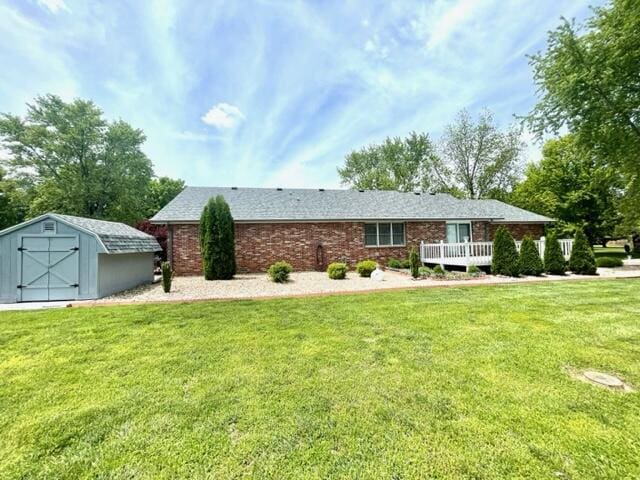 view of front of home with a storage unit, an outdoor structure, and a front lawn
