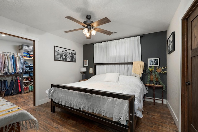 bedroom with a closet, wood finished floors, baseboards, and ceiling fan