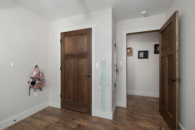 foyer with baseboards and dark wood finished floors