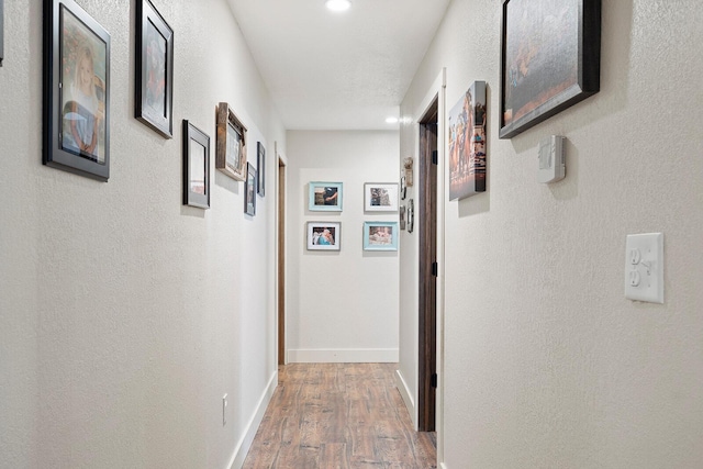 corridor with recessed lighting, baseboards, and wood finished floors