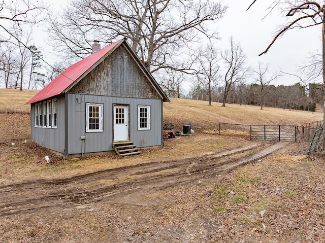 view of outbuilding featuring entry steps, an outbuilding, and fence