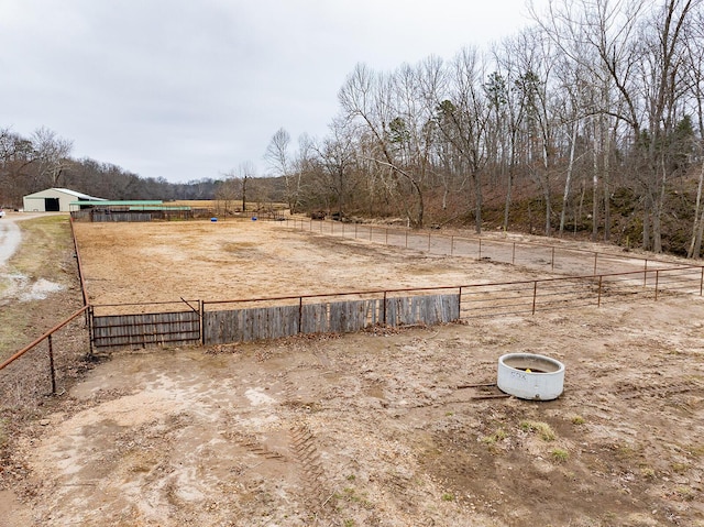 view of yard featuring fence, a rural view, and an outbuilding