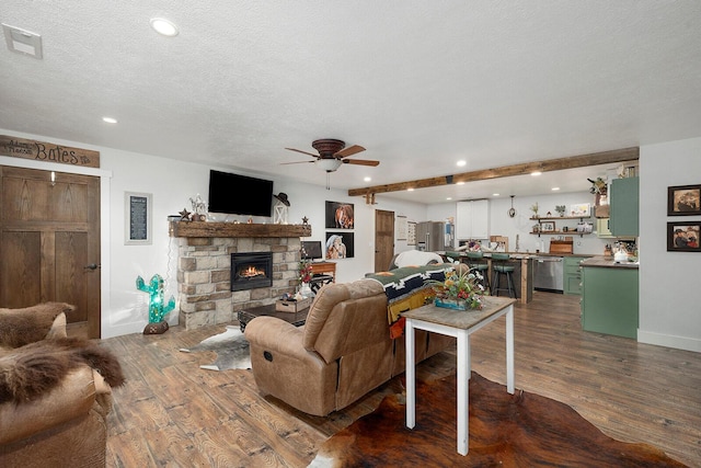 living area with visible vents, a fireplace, ceiling fan, and dark wood-style floors