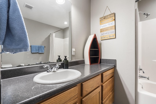 bathroom featuring vanity, visible vents, and shower / bath combo