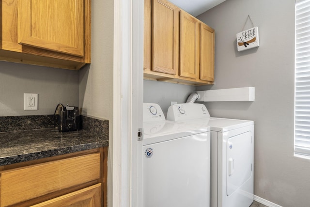 clothes washing area with baseboards, cabinet space, and washer and clothes dryer