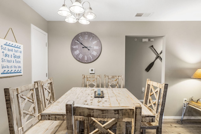 dining space with baseboards, visible vents, a chandelier, and light wood-type flooring