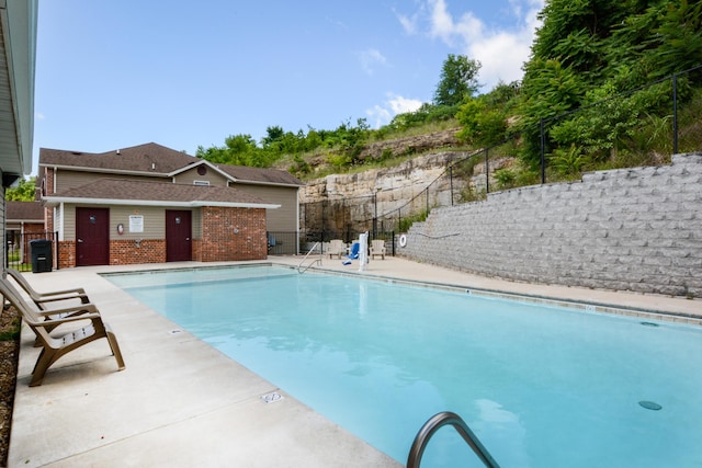 community pool featuring fence and a patio