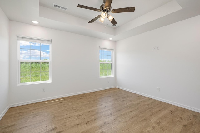 empty room with light wood finished floors, visible vents, baseboards, and recessed lighting