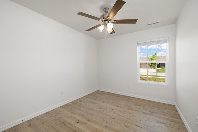 spare room with light wood-type flooring, visible vents, baseboards, and ceiling fan