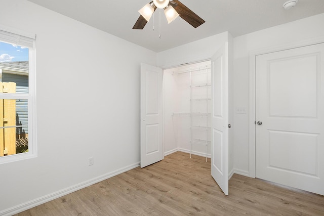 unfurnished bedroom with ceiling fan, a closet, light wood-type flooring, and baseboards