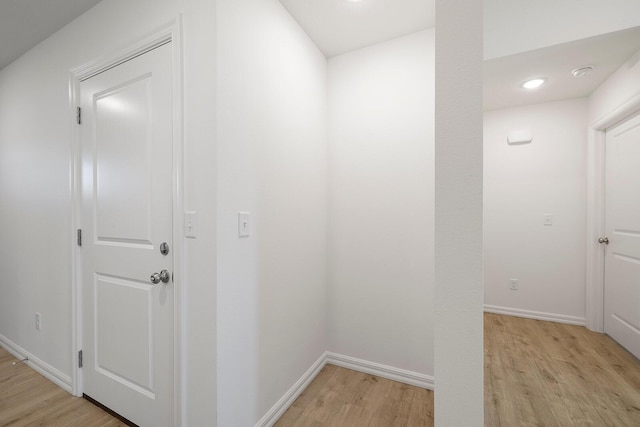 corridor featuring baseboards, recessed lighting, and light wood-type flooring