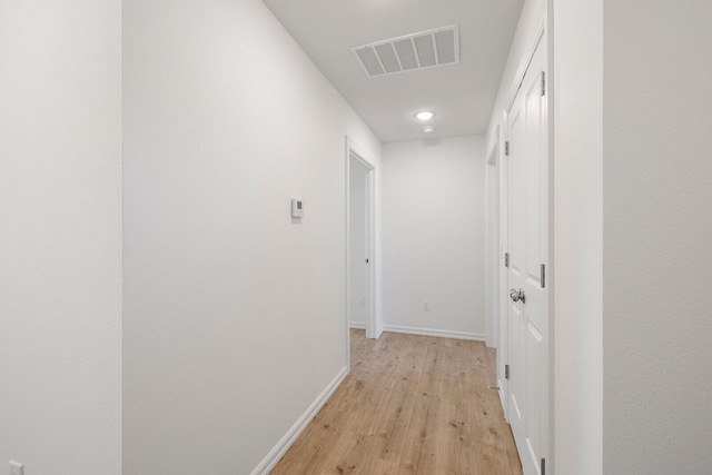 corridor with light wood-style floors, visible vents, baseboards, and recessed lighting