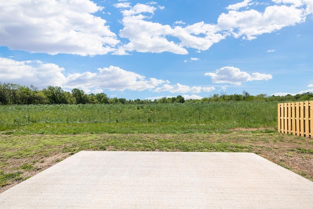 view of patio featuring a rural view and fence