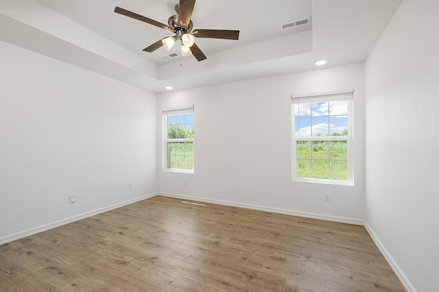 unfurnished room with baseboards, light wood finished floors, recessed lighting, and visible vents