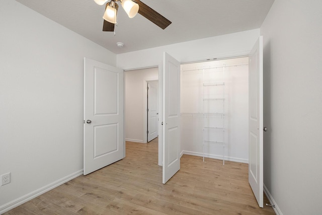 unfurnished bedroom featuring baseboards, a closet, and light wood-type flooring