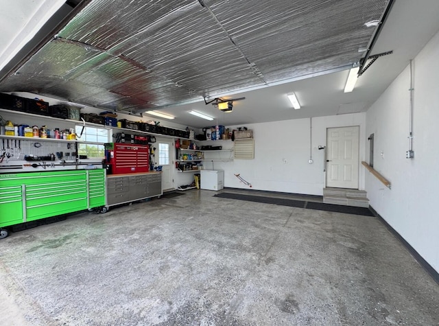 garage featuring a workshop area, baseboards, and a garage door opener