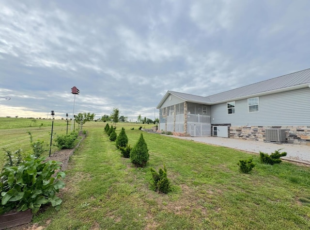 view of yard with a sunroom and central air condition unit