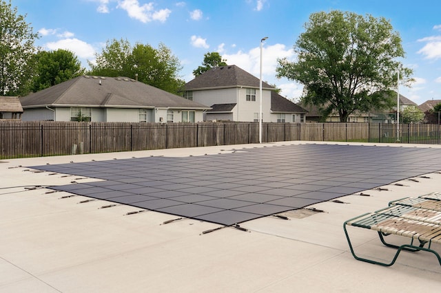 view of pool with a patio area, fence, and a residential view