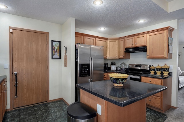 kitchen featuring a textured ceiling, a center island, under cabinet range hood, dark countertops, and stainless steel appliances