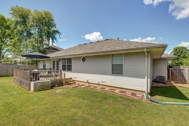 rear view of house featuring cooling unit, fence, a deck, and a lawn