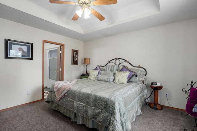 bedroom featuring a raised ceiling, carpet, baseboards, and a ceiling fan