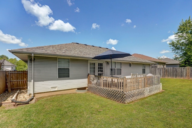 rear view of house with a yard, a wooden deck, a fenced backyard, and a shingled roof