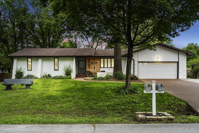 ranch-style home featuring concrete driveway, an attached garage, and a front yard
