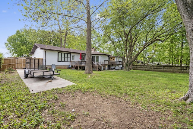 view of yard featuring a fenced backyard, a wooden deck, and a patio