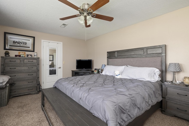 carpeted bedroom with a ceiling fan, visible vents, and a textured ceiling
