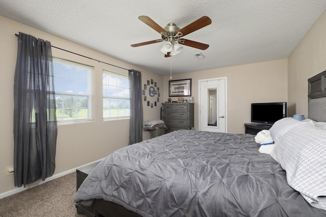carpeted bedroom featuring ceiling fan, a textured ceiling, baseboards, and visible vents