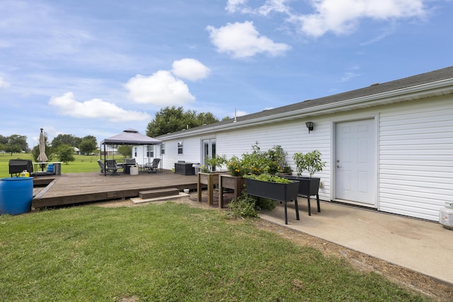 back of property featuring a yard, a gazebo, a wooden deck, and outdoor dining area