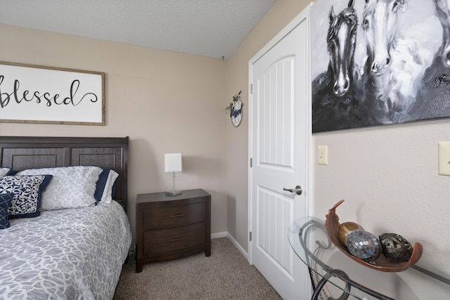 carpeted bedroom featuring a textured ceiling and baseboards