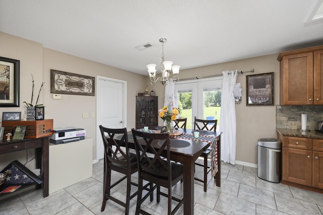 dining area featuring an inviting chandelier, visible vents, and baseboards