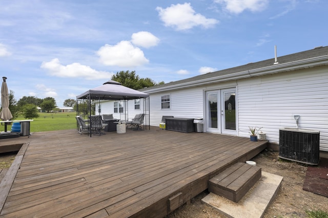 wooden terrace featuring central AC, a gazebo, french doors, and an outdoor living space