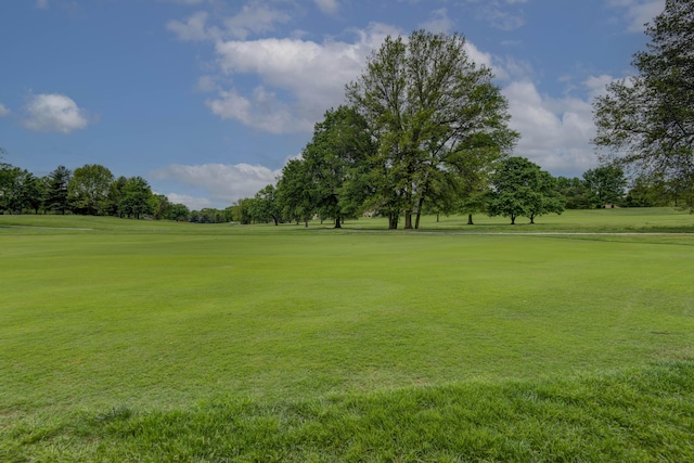 view of property's community with golf course view and a lawn