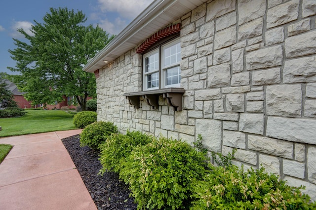 view of property exterior featuring stone siding and a lawn