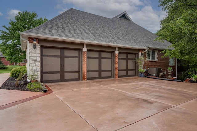 garage featuring concrete driveway and central AC
