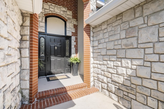 entrance to property with stone siding and brick siding