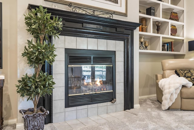 detailed view of a tile fireplace, carpet flooring, and baseboards