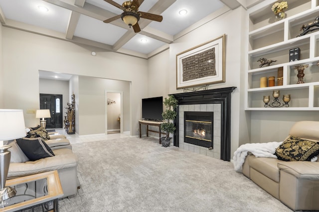 carpeted living room featuring coffered ceiling, ceiling fan, a fireplace, and beam ceiling