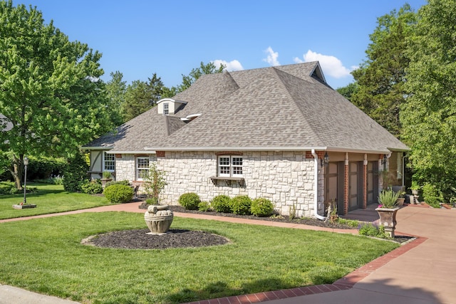 view of side of home with stone siding, a yard, a shingled roof, and an attached garage
