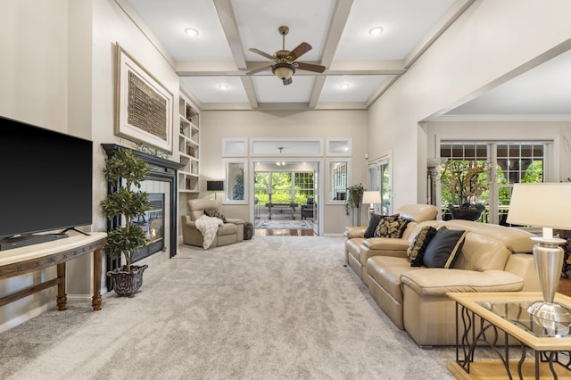 carpeted living area featuring a tile fireplace, ceiling fan, coffered ceiling, beam ceiling, and baseboards