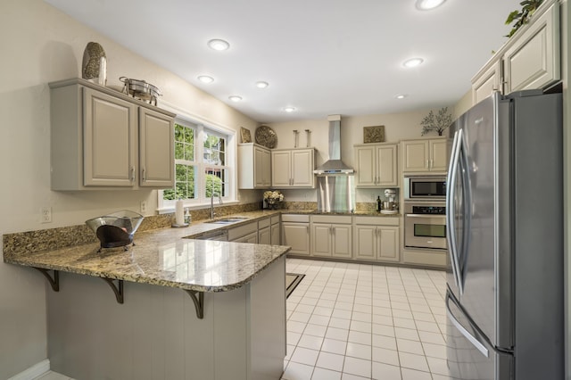 kitchen with stainless steel appliances, wall chimney exhaust hood, a peninsula, a sink, and light tile patterned floors