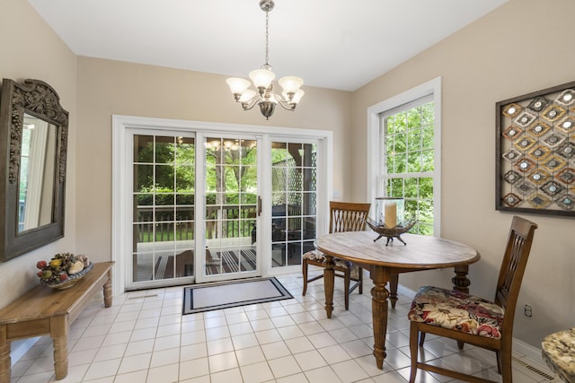 doorway to outside with a chandelier, baseboards, and light tile patterned flooring