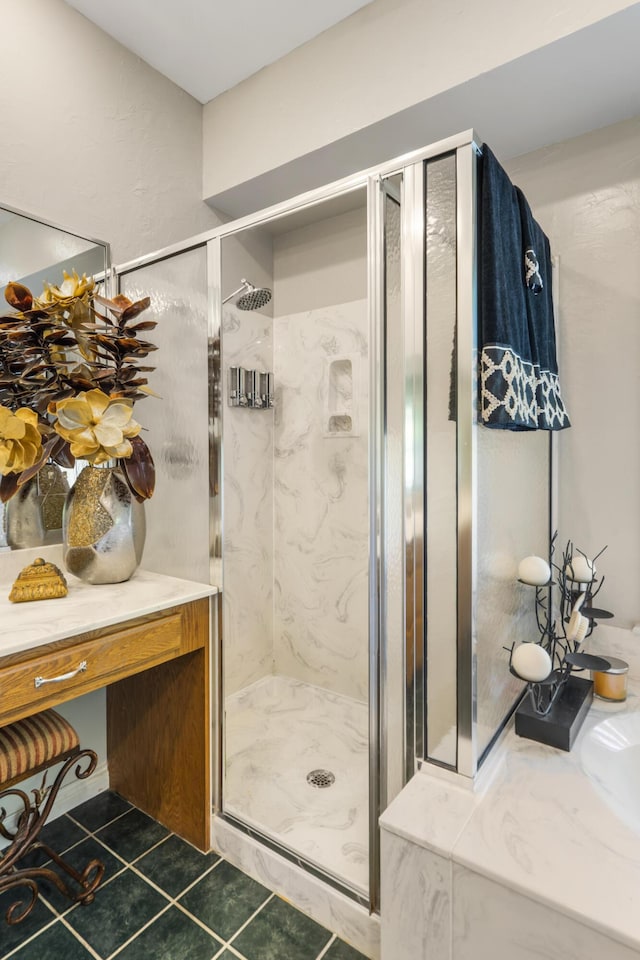 bathroom with a shower stall and tile patterned floors