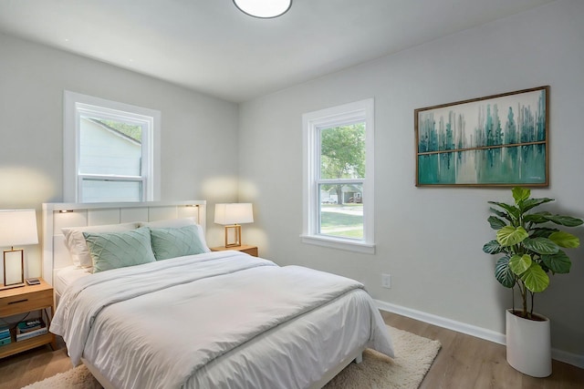 bedroom with baseboards and wood finished floors