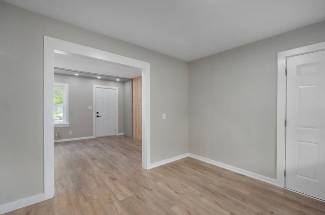 spare room featuring light wood-type flooring and baseboards