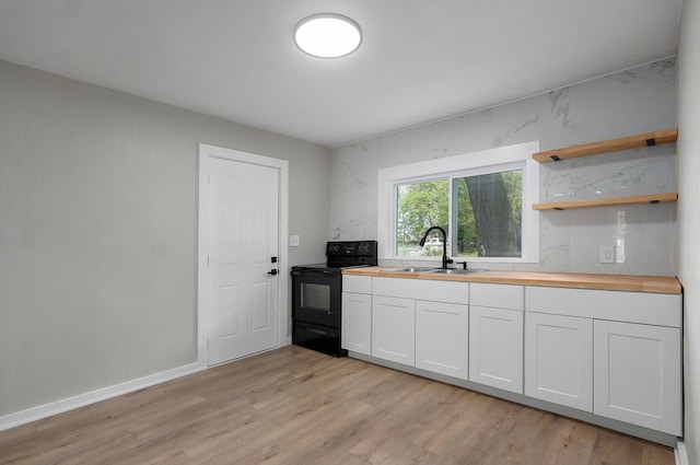 kitchen featuring wood counters, a sink, black / electric stove, and light wood-style floors