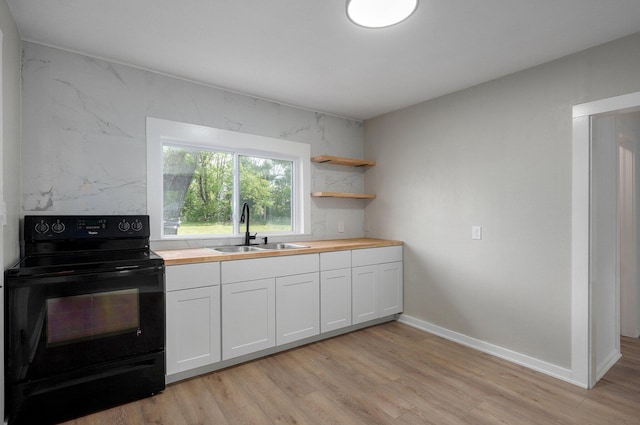 kitchen with light wood-style flooring, a sink, wood counters, baseboards, and black electric range oven